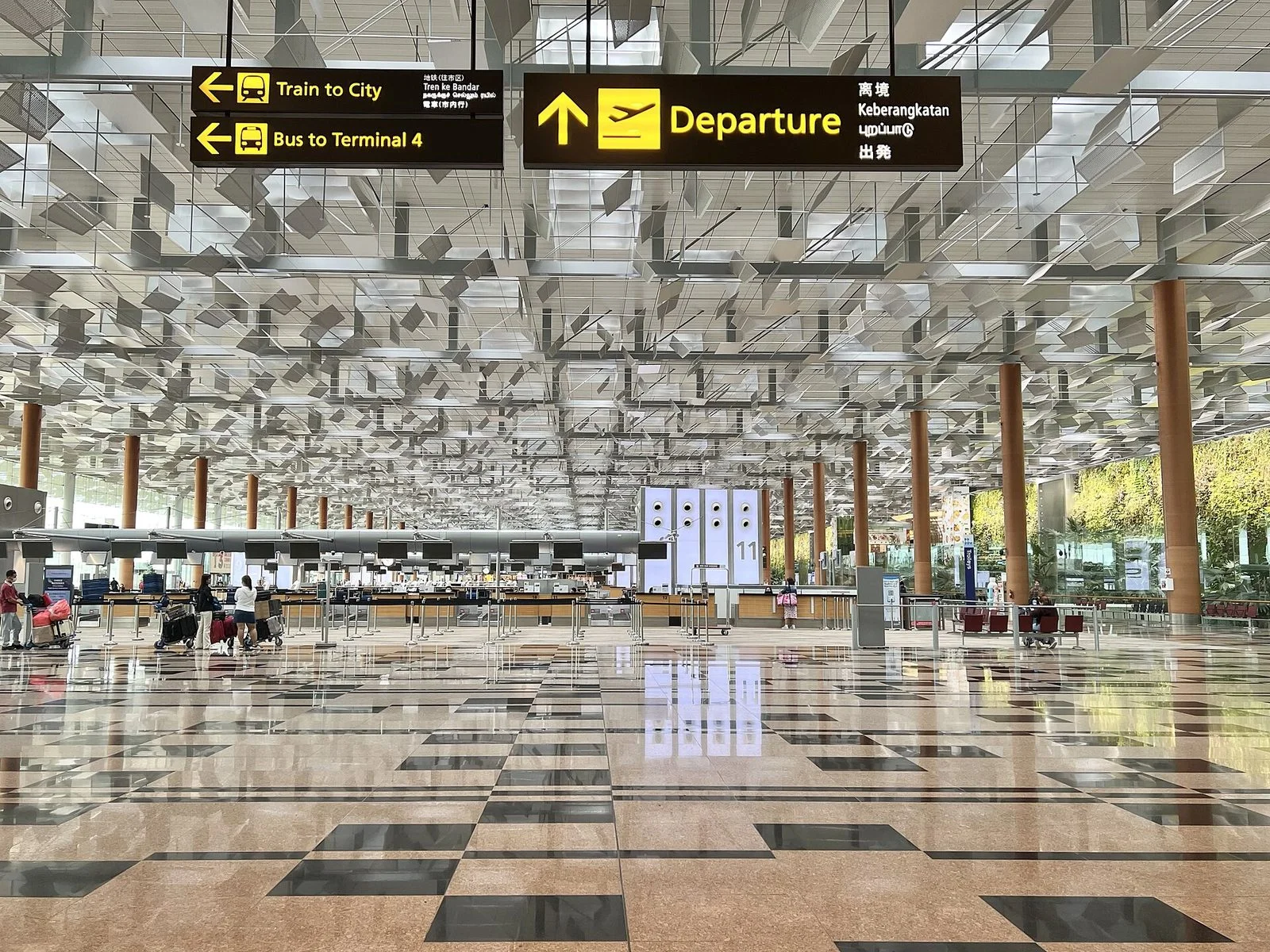 Grand hall lumineux de l'aéroport de Changi, sol en damier, comptoirs d'enregistrement au fond et panneaux « Departure » et « Train to City »