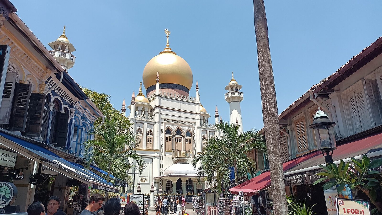 La mosquée du Sultan, avec son dôme doré et ses minarets, vue depuis Bussorah Street bordée de shophouses et de palmiers