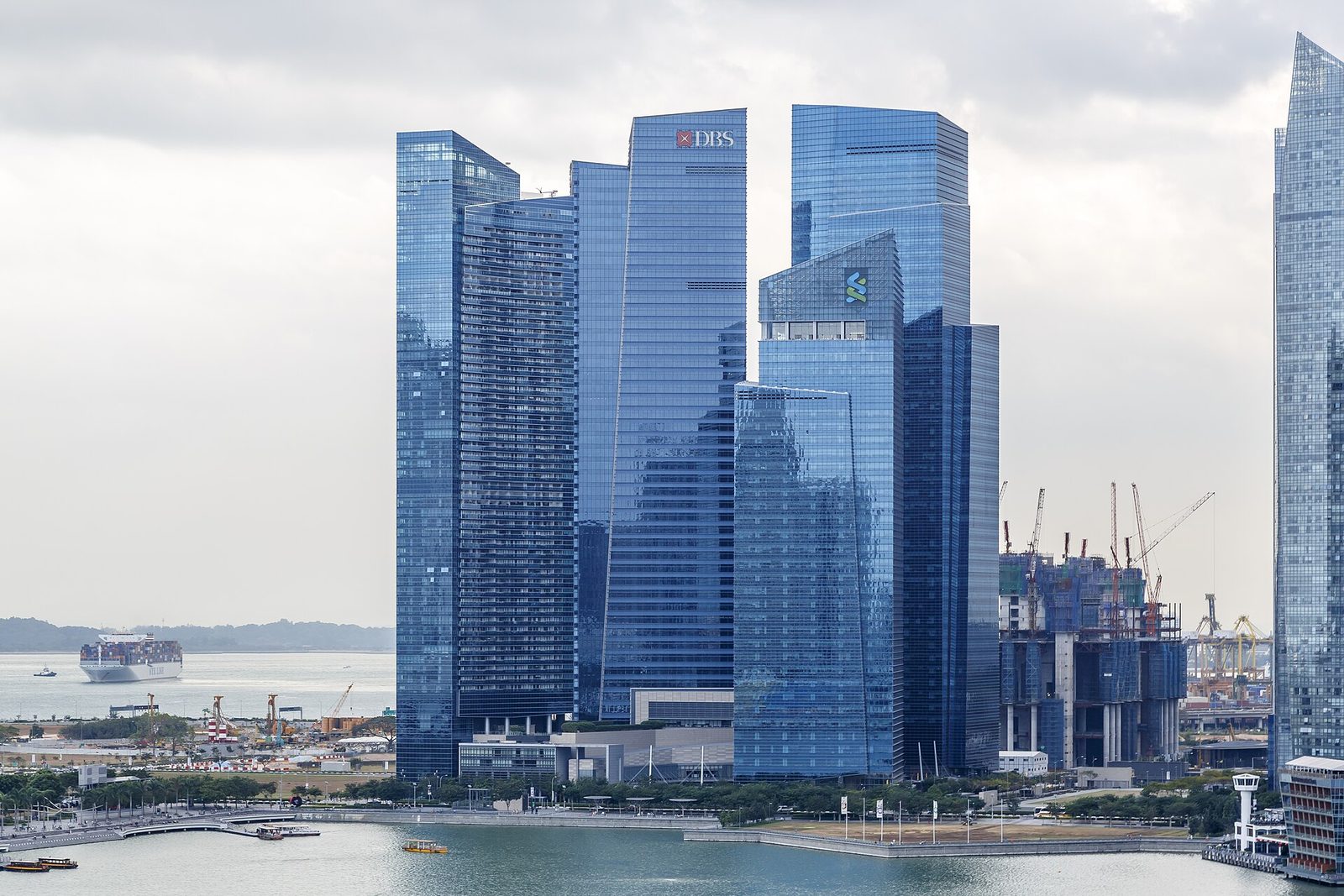 Les tours de verre bleu du Marina Bay Financial Centre, dont l'une porte le logo rouge de DBS et une autre celui de Standard Chartered