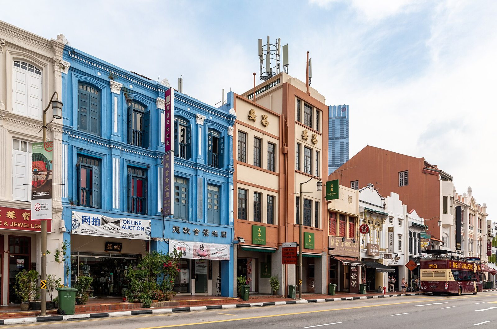 Rangée de shophouses colorées de Chinatown, dont une façade bleue, avec des enseignes en chinois et en anglais