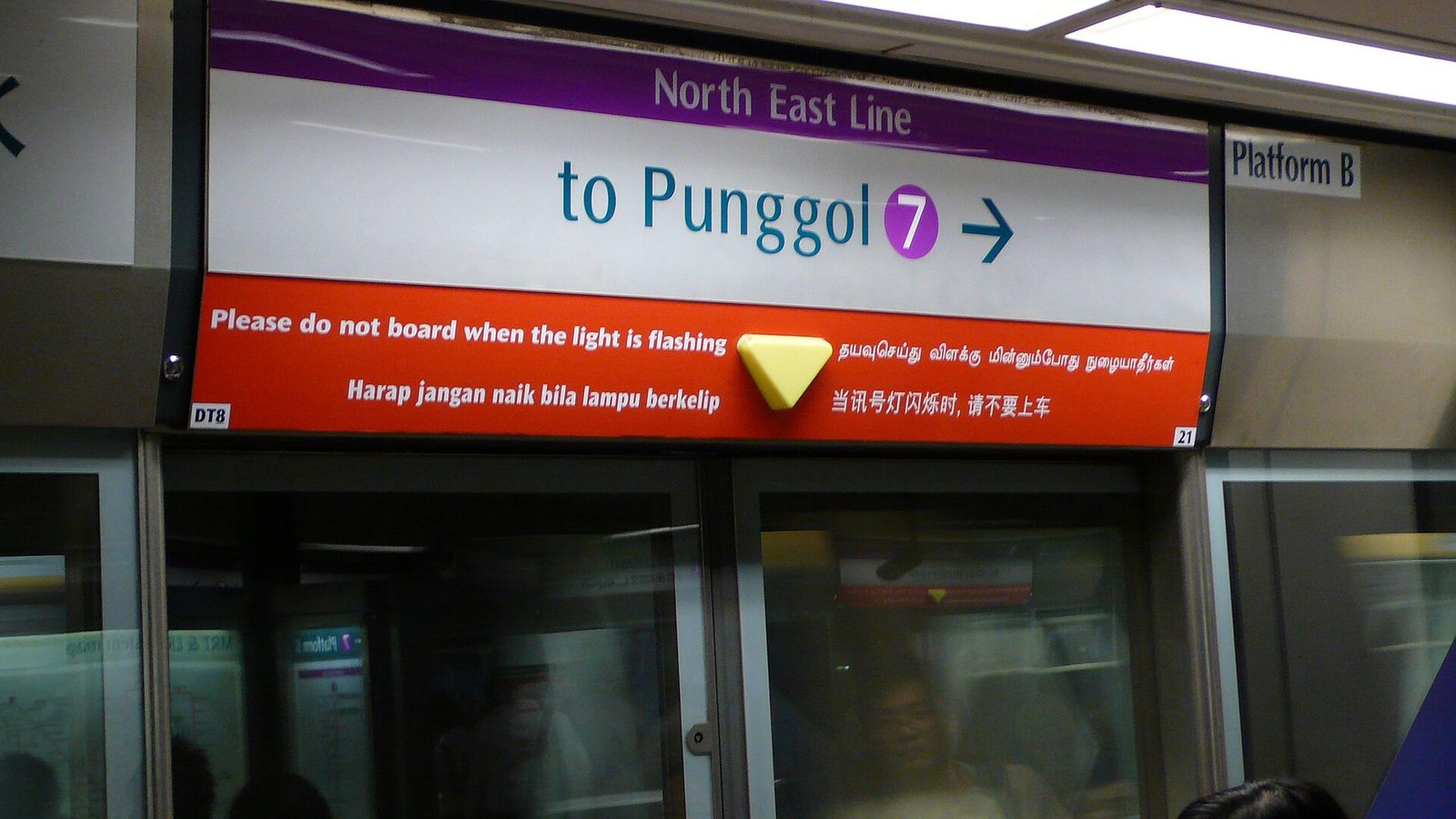 Panneau de quai du métro de Singapour sur la North East Line, direction Punggol, avec une consigne de sécurité écrite en anglais, en tamoul, en malais et en chinois