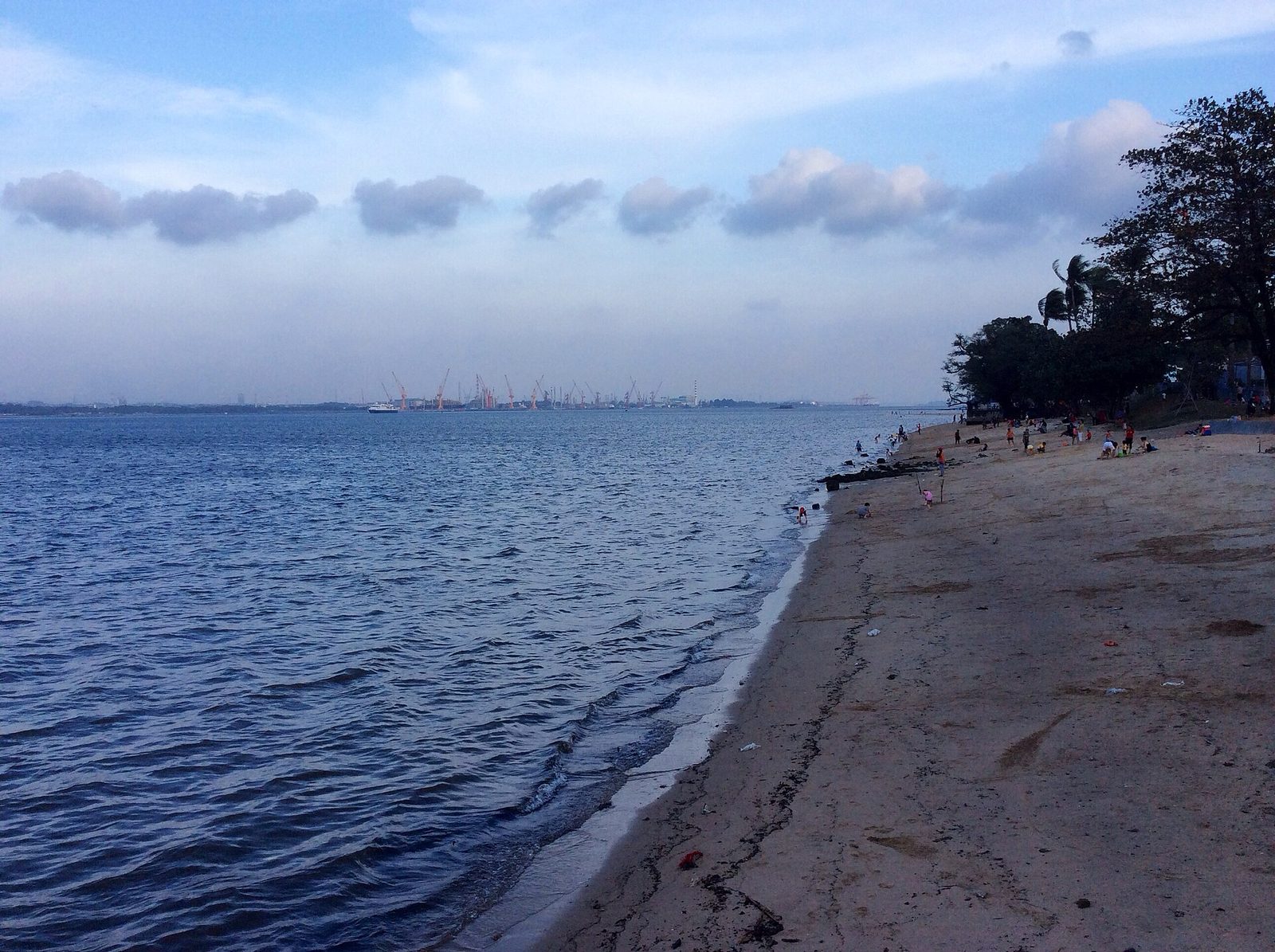 La plage de sable de Sembawang Park bordée d'arbres, face aux eaux calmes du détroit de Johor