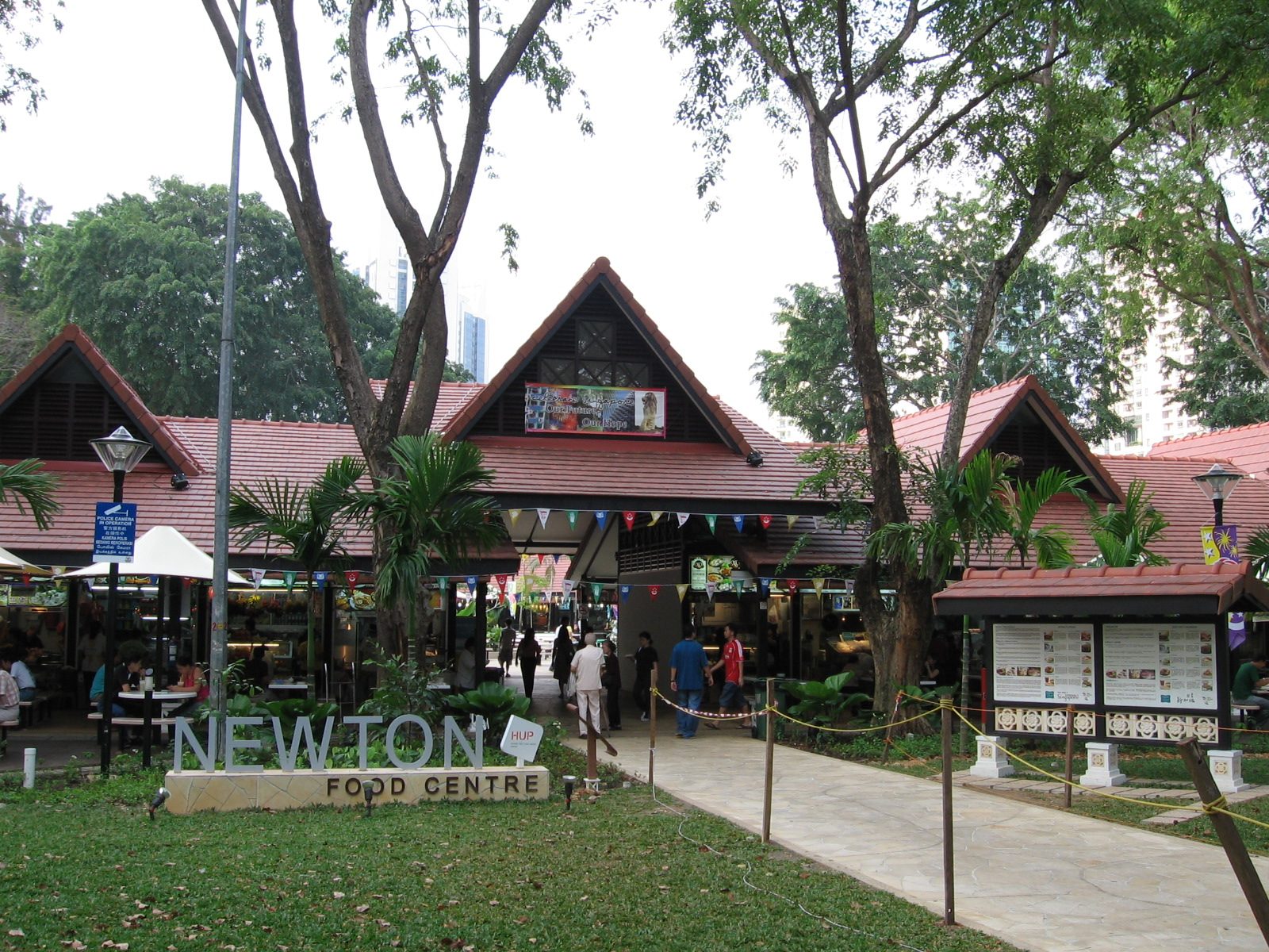 Entrée du Newton Food Centre, ses toits de tuiles rouges et son jardin arboré