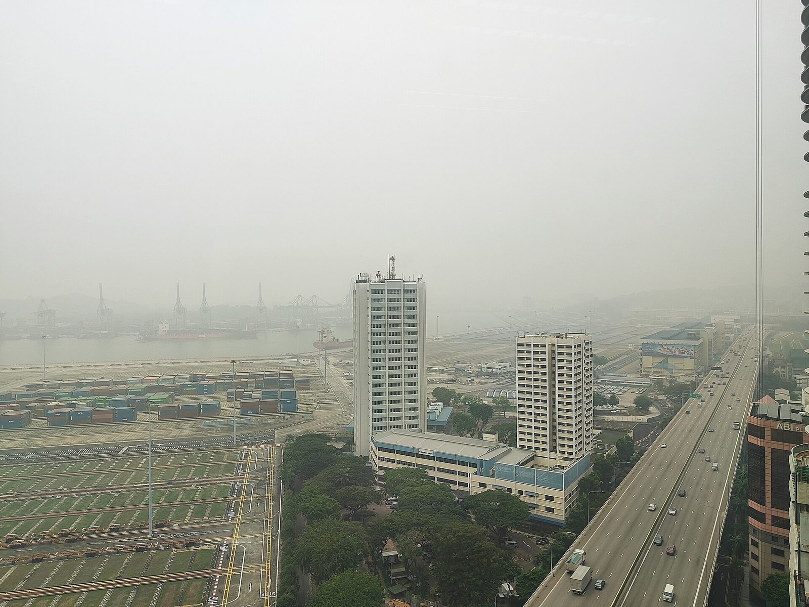 Le terminal à conteneurs de Tanjong Pagar et une voie rapide, à peine visibles dans une brume grise
