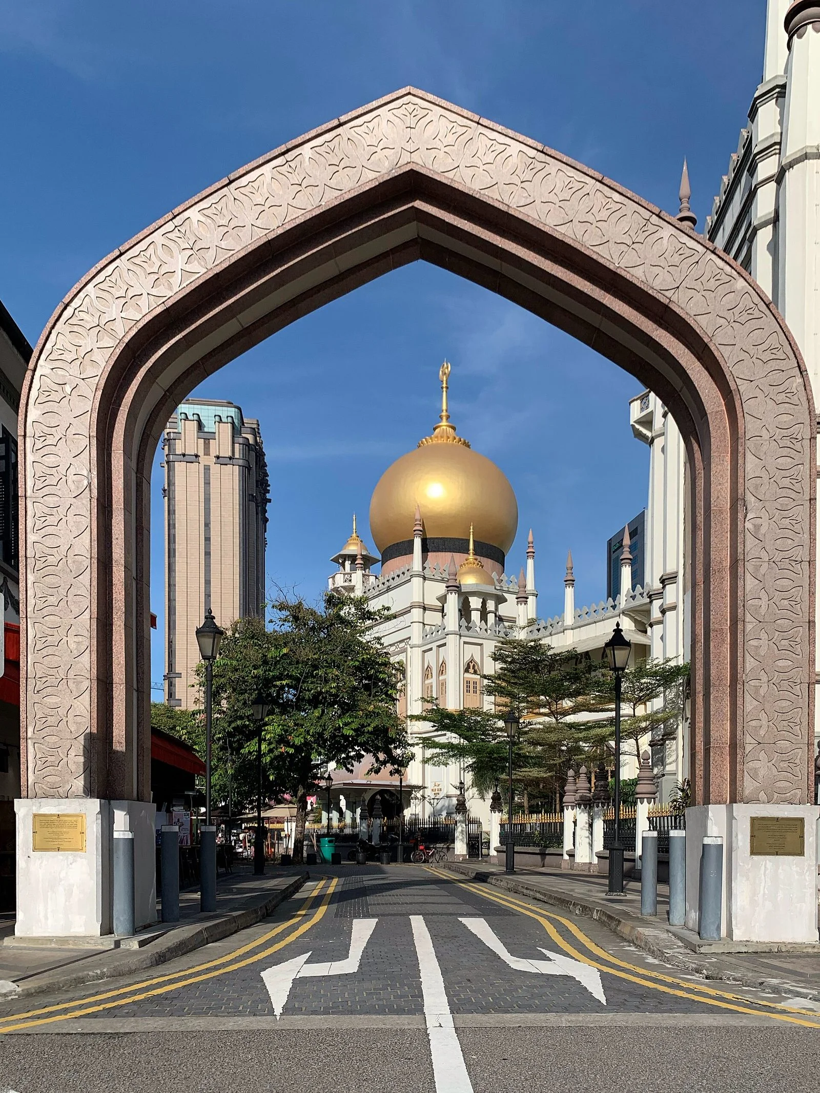 Le dôme doré de la mosquée du Sultan vu à travers une grande arche sculptée, dans le quartier de Kampong Glam